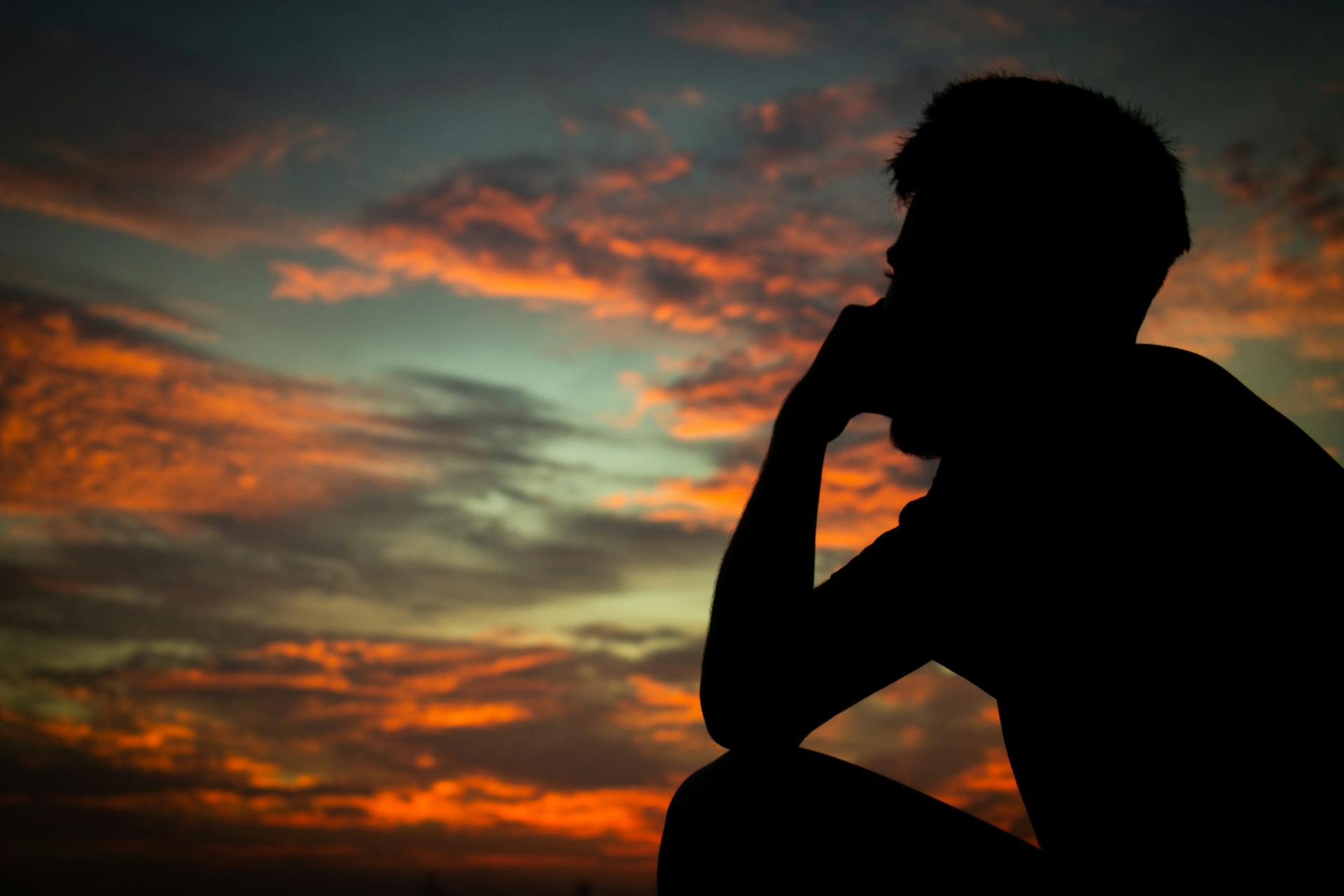 Silhouette of man thinking at sunset
